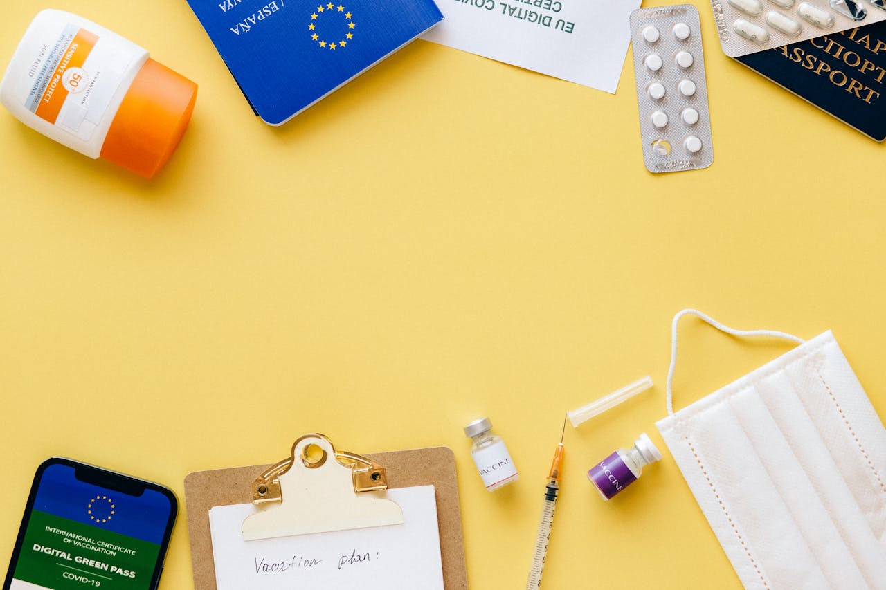 about-01 Flat lay of travel essentials including passport, mask, and vaccination pass.